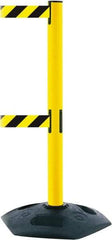 Tensator - 38" High, 2-1/2" Pole Diam, 4 Way Stanchion - 19" Base Diam, Octagon Recycled Rubber Base, Yellow Plastic Post, 7-1/2' x 2" Tape, Dual Line Tape, For Outdoor Use - Eagle Tool & Supply